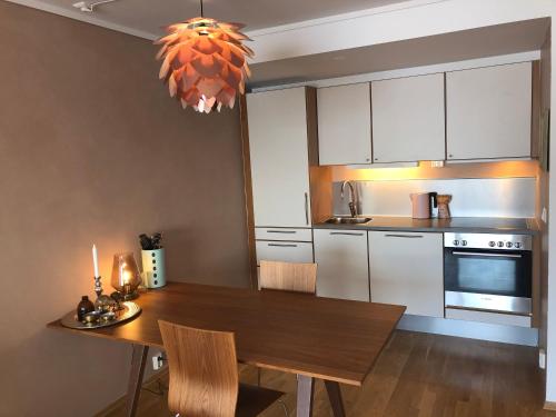 NordseterにあるMountain View Apartment with Saunaのキッチン(木製テーブル、椅子、シャンデリア付)