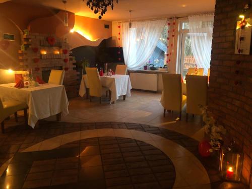 a restaurant with two tables and chairs and a room at Sosnowe Zacisze in Białystok