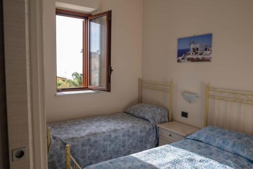 1 dormitorio con 2 camas y ventana en La rosa dei venti, apartment 2, en Porto Empedocle