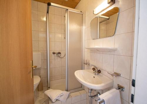 a bathroom with a sink and a shower at Pension Nina & Gasthof Alpenrose in Gschnitz