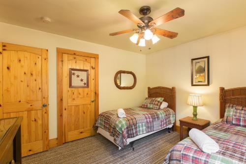 a bedroom with two beds and a ceiling fan at Rooster Ridge in Hendersonville