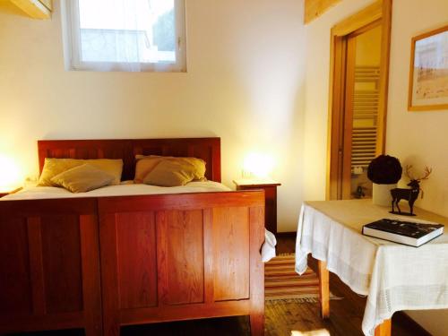 a bedroom with a bed and a table and a window at La terrazza gardenese in Santa Cristina Gherdëina