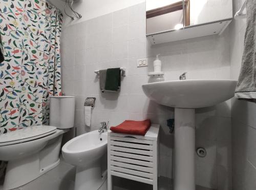 Baño blanco con lavabo y aseo en Nel Centro Storico A Casitta Da Mola en Castelmola