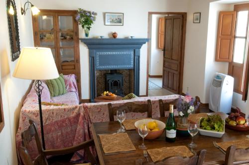 een woonkamer met een tafel en een open haard bij El Cortijo at Molino la Ratonera in Zagra
