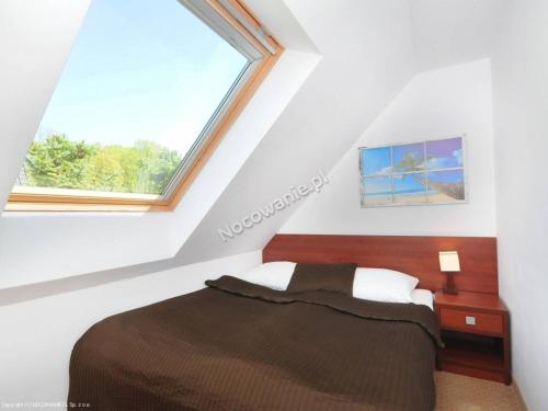 a bedroom with a bed and a window at Pod Muzami in Rewal