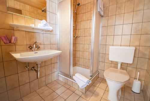 y baño con aseo, lavabo y ducha. en Gasthof Alpenrose und Pension Nina, en Gschnitz
