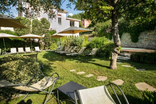 a group of chairs and umbrellas in a yard at Relais Del Maro in Borgomaro