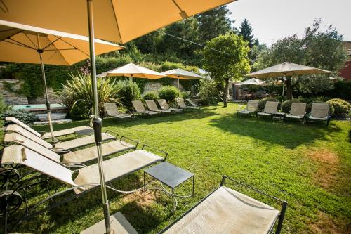 a group of chairs and umbrellas in a yard at Relais Del Maro in Borgomaro