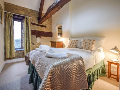 um quarto com uma cama grande e toalhas em Butts Farm em Cirencester