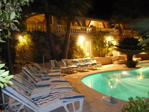 a group of lounge chairs next to a swimming pool at Villa spa hamman sauna Piscine 9 chambres in Juan-les-Pins