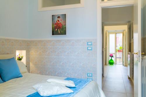 a bedroom with a blue and white bed and a hallway at Casa Parravano in Caserta