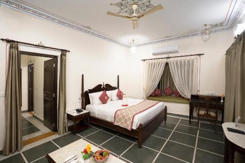 a bedroom with a bed and a desk in a room at The Amargarh in Udaipur