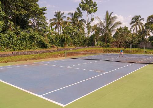 a person playing tennis on a tennis court at Mansión Los Guichos in Retalhuleu