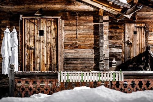 a wooden house with a door and a fence at Caravan Park Sexten in Sesto