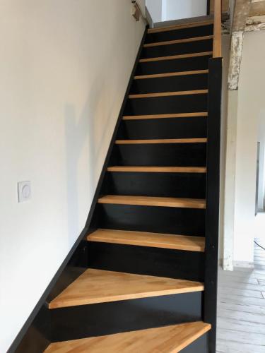 a staircase in a house with black and wooden steps at Appartements de Charme in Corte