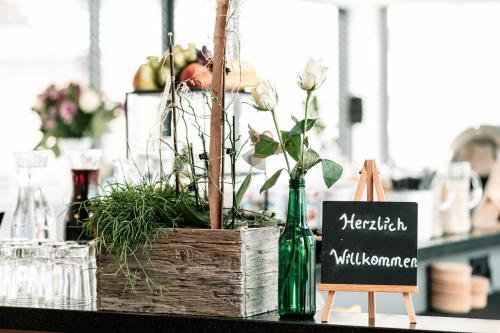 einen Tisch mit einer Holzkiste mit Pflanzen und einem Schild in der Unterkunft Motel Grieskirchen superior in Grieskirchen