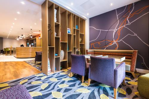 a waiting area with chairs and a table in a lobby at Holiday Inn Rotherham-Sheffield M1,Jct.33 by IHG in Rotherham