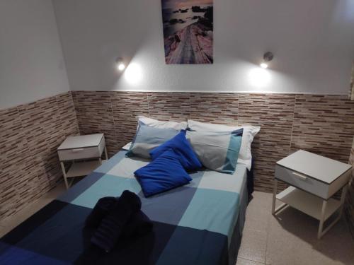 a bedroom with a bed with blue and white pillows at Apartamento Happyness Complex Amaya Fuerteventura in Costa de Antigua