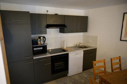 a kitchen with gray cabinets and a sink at Haus Alfina in Alf