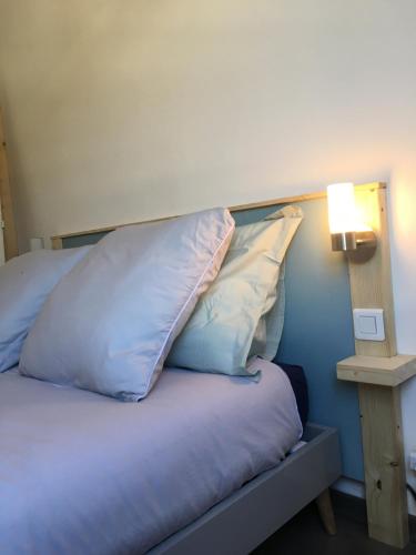 a bed with two pillows on it next to a lamp at Studio des Eterlous in Saint-Chaffrey