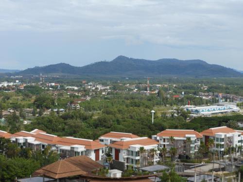 a city with houses and mountains in the background at Top Floor, One-Bedroom Apartment in Phuket