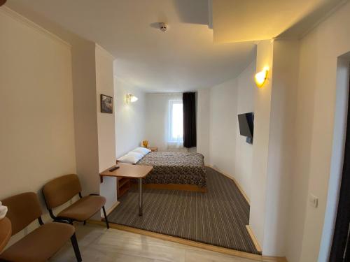 a hotel room with a bed and a table and chairs at Autopark Hotel in Lviv