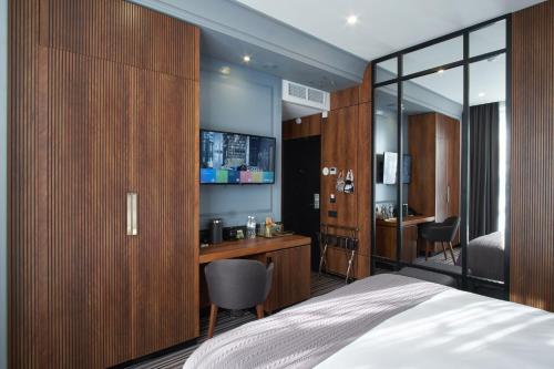 a bedroom with a bed and a desk and a chair at ARKA Hotel by Ginza Project in Rostov on Don