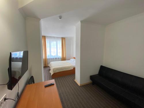 a living room with a couch and a bed at Autopark Hotel in Lviv