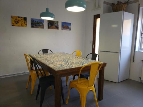 a dining room table with yellow chairs and a refrigerator at Casa Mineta in Cretas