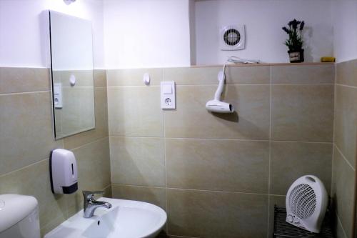a bathroom with a sink and a phone on the wall at Green Lake Airport Apartments in Vecsés