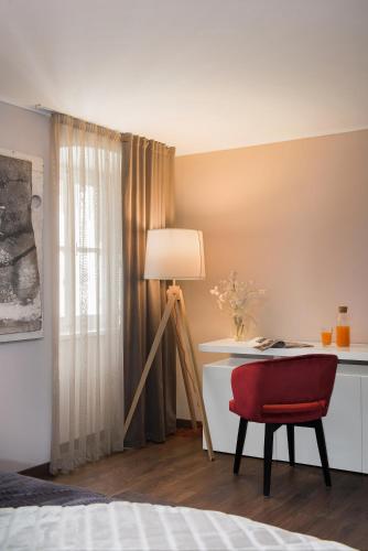 a bedroom with a desk and a red chair at Boutique Rooms Mirabilis in Skradin