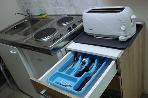 a toaster sitting on top of a counter next to a stove at Green Lake Airport Apartments in Vecsés