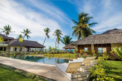 a villa with a swimming pool and a resort at Home The Residence in Befotaka Bay
