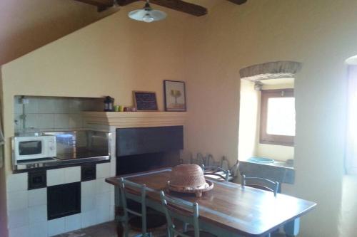 a kitchen with a table and a table and a microwave at La casita marrón in Palafrugell