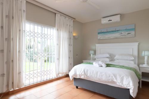 a bedroom with a bed and a large window at Comp Beach Road 25 - FAMILY ONLY in Ballito