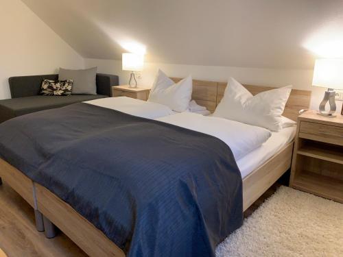 a bedroom with a large bed and a couch at Hohe Tanne in Aurbach