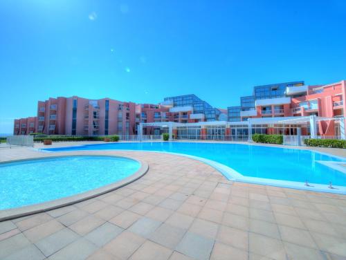 ein großer Pool vor einigen Apartmentgebäuden in der Unterkunft APPARTEMENT 46M², 1 CHAMBRE, PISCINE, TENNIS, PLAGE DIRECT in Sète