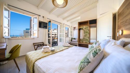 a bedroom with a large bed and a large window at PLAZAsuite1600 in Rethymno