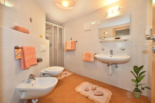 a bathroom with two sinks and a toilet and a mirror at Nagelehof in Ridanna