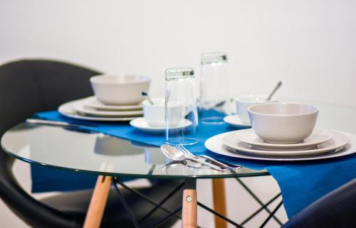 a glass table with plates and cups on it at 1 Bedroom Apartment Leamington Spa Hosted By Golden Key in Warwick