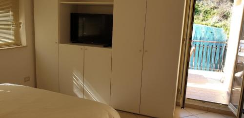 une chambre avec une télévision à écran plat sur une armoire dans l'établissement B&B Iris, à Taormine