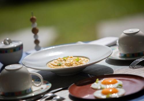 a table with a plate of food on a table at Hôtel Les Frères Ibarboure in Bidart