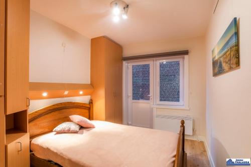 um pequeno quarto com uma cama e uma janela em Opale 0101 em Koksijde