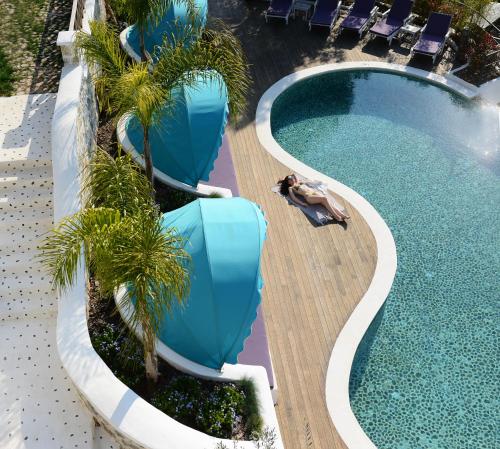 a swimming pool with palm trees in a resort at Hotel Unique-Boutique Class - Adults Only in Fethiye