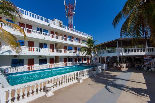 a hotel with a swimming pool and palm trees at Hotel Boquilla Suites By GEH Suites in Cartagena de Indias