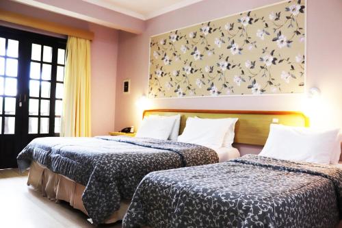 a hotel room with two beds and a painting on the wall at Hotel do Santuário in Nova Trento