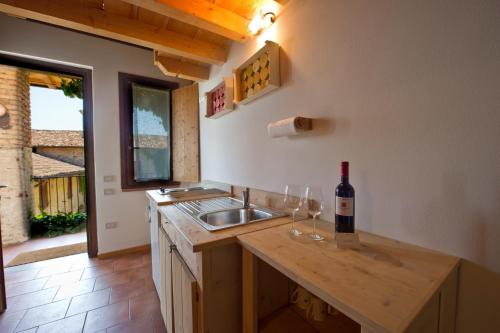 a kitchen with a sink and a bottle of wine on a counter at Borgo San Donino in Desenzano del Garda