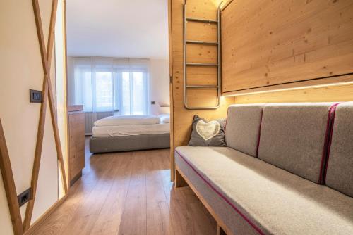 a bedroom with a bed and a couch in a room at Veronza Clubresidence in Cavalese