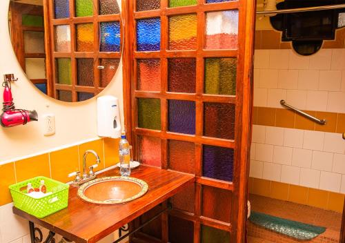 a bathroom with a sink and a shower with stained glass at Mansión Los Guichos in Retalhuleu