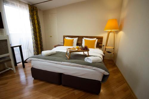a bedroom with a bed with a table on it at Hotel Cordata in Tbilisi City
